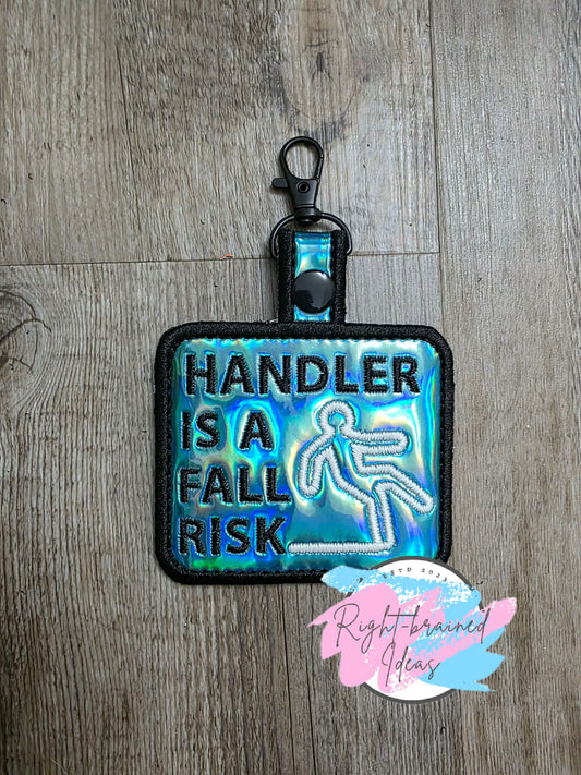 Handler Is A Fall Risk Black And Glow-In-The-Dark White On Light Blue Holographic Vinyl Patch Tab