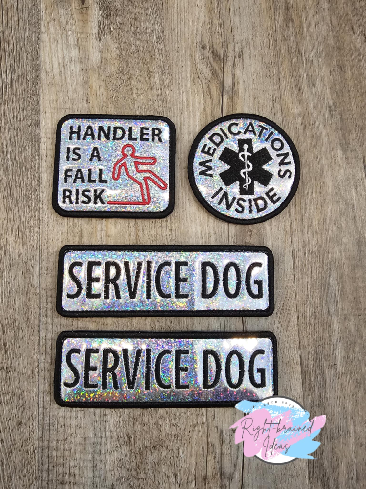 This is a four-piece patch set made with sparkle silver holographic vinyl and black, red and white embroidery thread. All patches have velcro sewn on the backside.&nbsp;

Set Includes:&nbsp;

(2) 6in x 2in rectangular patches: "Service Dog"

(1) 3in circular patch: "Medication Inside" around a medical symbol

(1) 2.5in x 3in rectangular patch: "Handler Is A Fall Risk" next to a falling human figure symbol