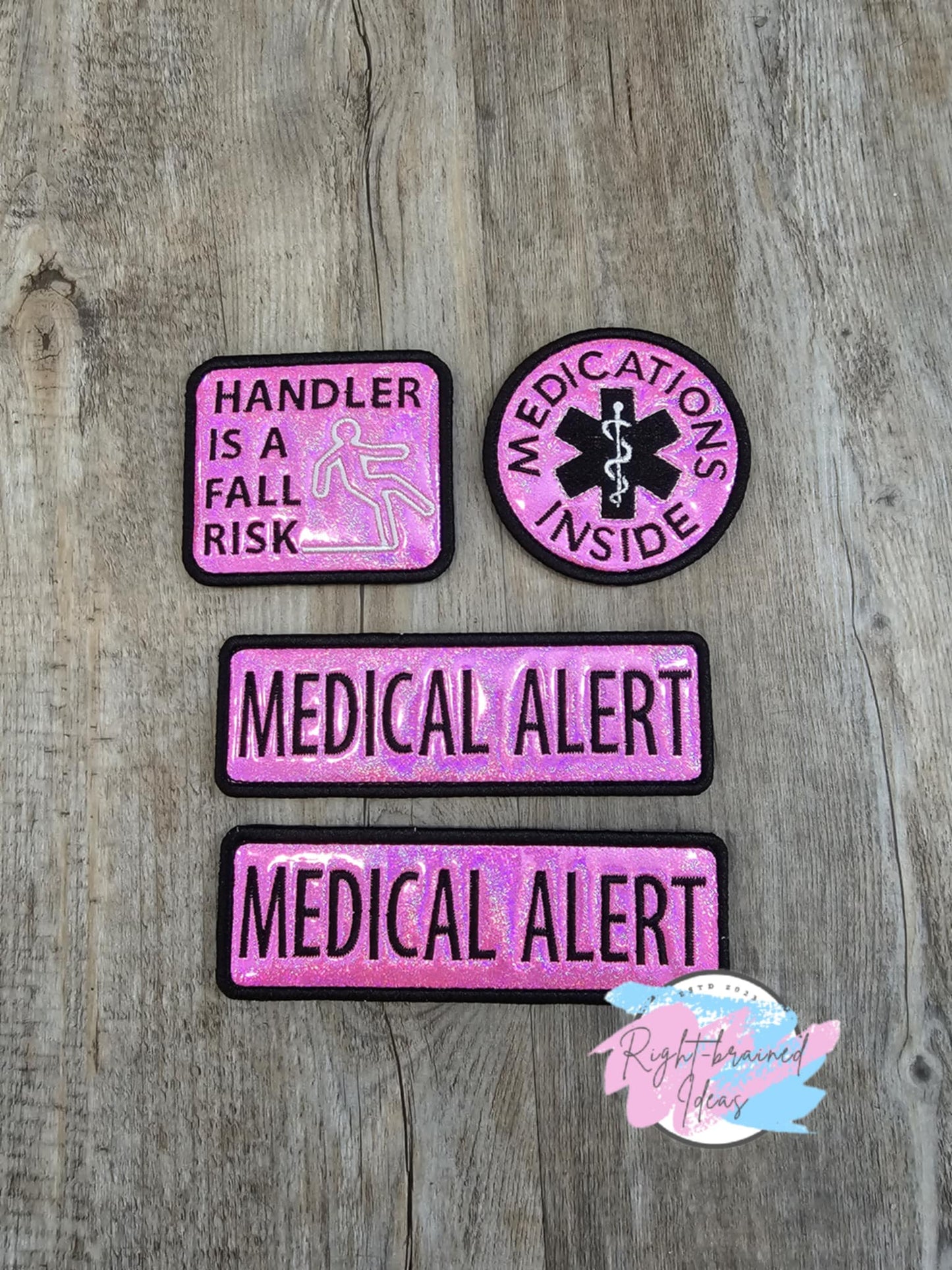 This is a four-piece patch set made with sparkle pink holographic vinyl and black and white embroidery thread. All patches have velcro sewn on the backside.&nbsp;

Set Inlcudes:&nbsp;

(2) 6in x 2in rectangular patches: "Medical Alert"

(1) 3in circular patch: "Medication Inside" around a medical alert symbol

(1) 2.5in x 3in rectangular patch: "Handler Is A Fall Risk" next to a falling human figure symbol